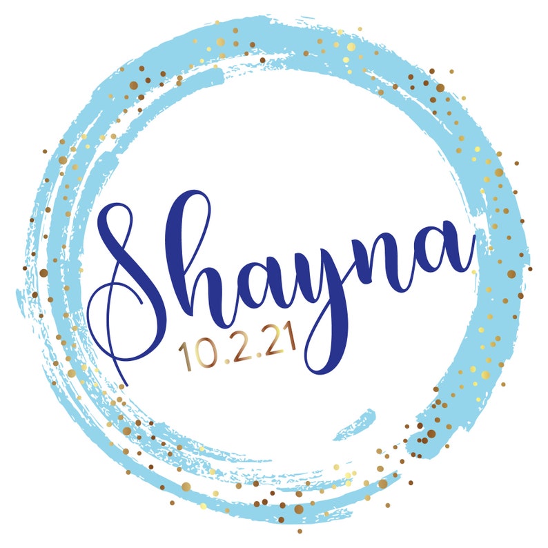 May include: A blue and gold circle with the name Shayna and the date 10.2.21 written in cursive.