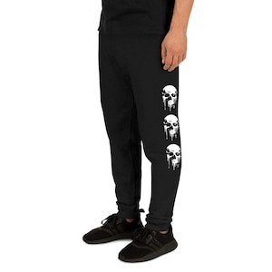 May include: Black sweatpants with a white skull graphic on the side of each leg. The skulls are dripping with white paint.