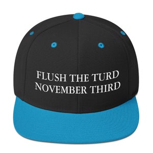 May include: A black and blue baseball cap with the text "FLUSH THE TURD NOVEMBER THIRD" embroidered in white.