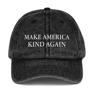May include: A black vintage-style baseball cap with the text "Make America Kind Again" in white lettering.