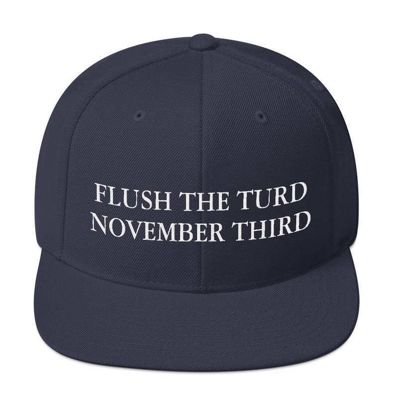 May include: A navy blue baseball cap with the text "FLUSH THE TURD NOVEMBER THIRD" embroidered in white on the front.