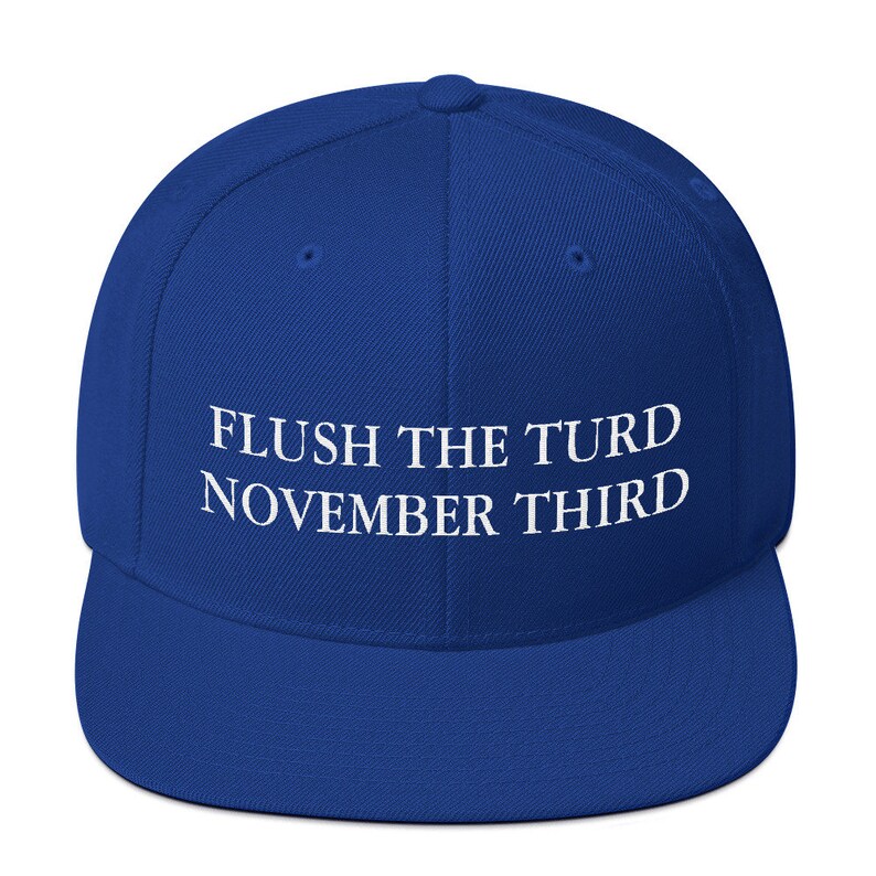 May include: A royal blue baseball cap with white embroidered text that reads "FLUSH THE TURD NOVEMBER THIRD".