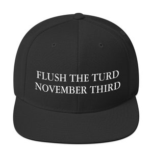 May include: Black baseball cap with white embroidered text that reads "FLUSH THE TURD NOVEMBER THIRD"