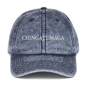May include: A blue denim baseball cap with the text "CHINGATUMAGA" embroidered in white on the front.