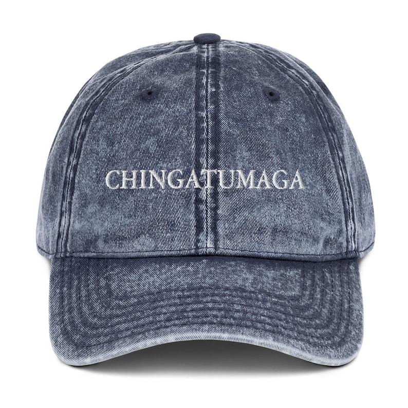 May include: A blue denim baseball cap with the text "CHINGATUMAGA" embroidered in white on the front.