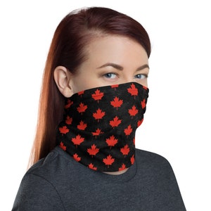 Op de afbeelding: Een zwart gezichtsmasker met een herhalend patroon van rode esdoornbladeren. Het masker is gemaakt van een zachte, ademende stof en is ontworpen om comfortabel te dragen.