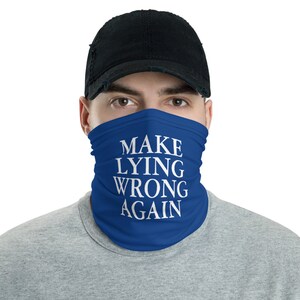 Może przedstawiać: Niebieska maska ​​na twarz z napisem "MAKE LYING WRONG AGAIN" w kolorze białym.