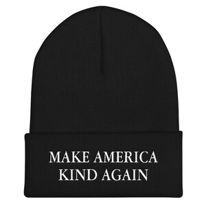 Puede incluir: Gorro de punto negro con texto bordado en blanco que dice "MAKE AMERICA KIND AGAIN".