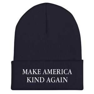 Puede incluir: Un gorro azul marino con el texto "MAKE AMERICA KIND AGAIN" bordado en blanco.