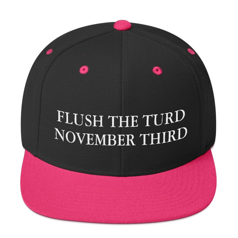 May include: Black and pink baseball cap with the text "FLUSH THE TURD NOVEMBER THIRD" embroidered in white.