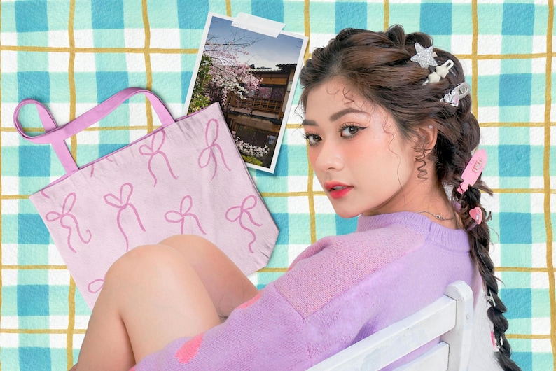 以下が含まれることがあります： ピンク色のリボンのトートバッグ、桜の咲く建物の写真、ラベンダー色のセーターを着てヘアクリップをつけた人物。背景は青と黄色のチェック柄です。
