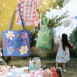 Puede incluir: Una bolsa tote azul con dise&ntilde;os florales y el texto "Grazie mille!" cuelga cerca de una invitaci&oacute;n de fiesta. Tambi&eacute;n se ve una bolsa verde con un dise&ntilde;o de sol y una ni&ntilde;a con un vestido estampado.