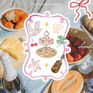 Puede incluir: Una escena de picnic con varios alimentos, incluyendo fruta, queso y pasteles. Un marco decorativo con garabatos de una paloma, cerezas y un viol&iacute;n est&aacute; en el centro. El texto "Playful doodles" es visible.