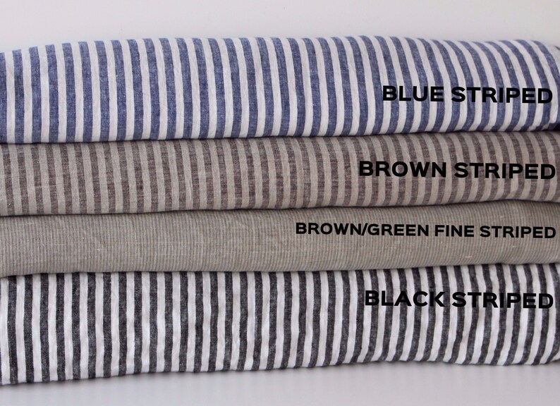 May include: Four different striped fabric swatches stacked on top of each other. The top swatch is blue and white striped, the second swatch is brown and white striped, the third swatch is brown and green striped, and the bottom swatch is black and white striped. The text on the swatches reads 'BLUE STRIPED', 'BROWN STRIPED', 'BROWN/GREEN FINE STRIPED', and 'BLACK STRIPED'.