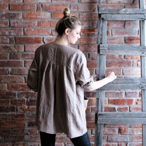 May include: A brown linen shirt with a long sleeve and a relaxed fit.