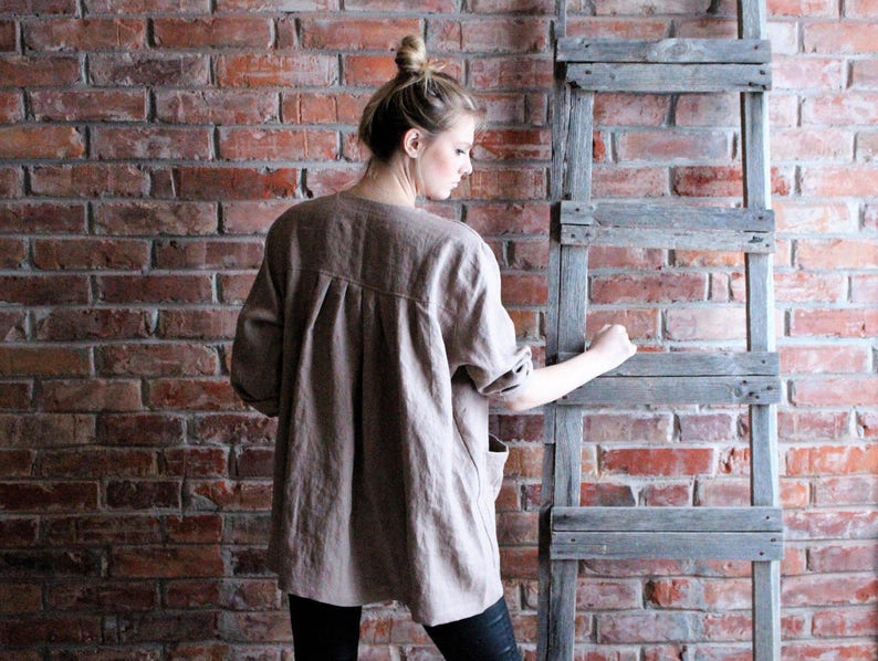 May include: A brown linen shirt with a long sleeve and a relaxed fit.