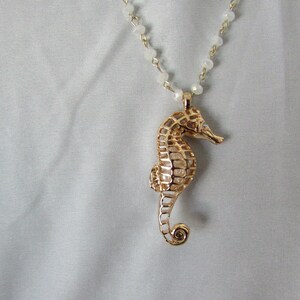 sea horse seahorse golden rhinestone and pearl reversible pendant on a cream colored pearlescent beaded necklace with coordinating bracelet