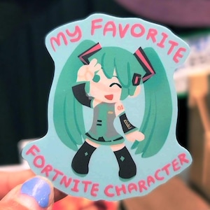 May include: A sticker with a cartoon character with long, teal hair and a teal and grey outfit. The sticker has the text "MY FAVORITE FORTNITE CHARACTER" in pink lettering on a light blue background.