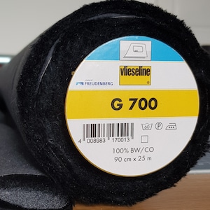 May include: A roll of black Vlieseline G 700 interfacing fabric. The label indicates it is 100% cotton and is 90 cm x 25 m.
