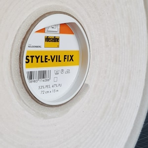 Puede incluir: Un rollo de cinta adhesiva blanca con una etiqueta amarilla que dice "vlieseline STYLE-VIL FIX". La etiqueta tambi&eacute;n incluye un c&oacute;digo de barras, instrucciones de lavado y la composici&oacute;n: 53% PES, 47% PU. La cinta mide 72 cm x 15 m.
