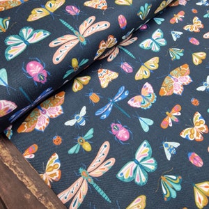 May include: A dark blue fabric featuring a repeating pattern of colourful butterflies and dragonflies. The fabric is ideal for crafting projects, quilting, and home decor.