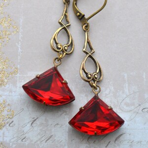 May include: A pair of dangle earrings with antique gold filigree and large red faceted glass stones.