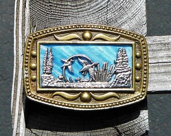 Fibbia per cintura con scena di fauna selvatica con anatre sullo stagno di CII New York - Design in argento su sfondo blu e tutto in ottone - Ottimo regalo - Italia Fibbia per cintura con scena di fauna selvatica con anatre sullo stagno di CII New York - Design in argento su sfondo blu e tutto in ottone - Ottimo regalo - Italia