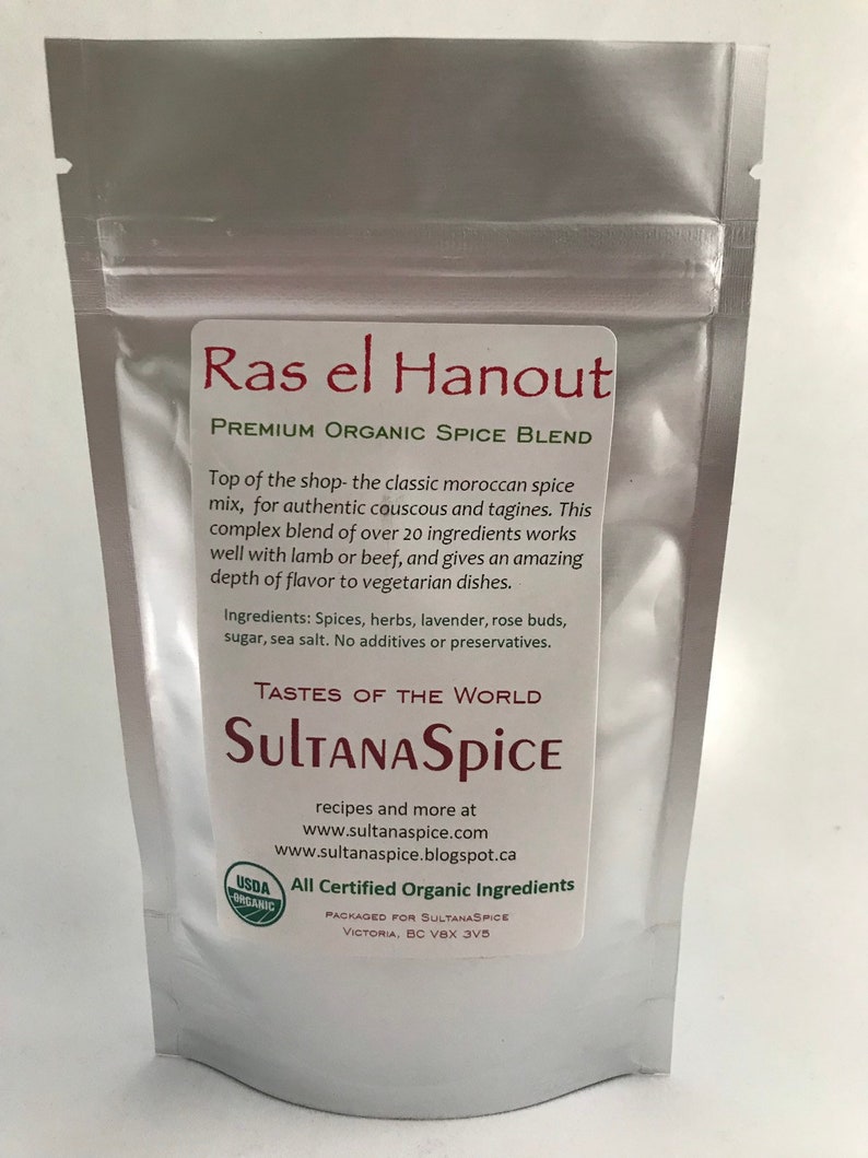 May include: A silver stand-up pouch containing Ras el Hanout premium organic spice blend. The label features the text Ras el Hanout, Premium Organic Spice Blend, SultanaSpice, and lists ingredients including spices, herbs, lavender, rose buds, sugar, and sea salt.