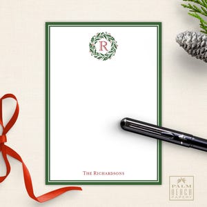 May include: Green and white holiday stationery with a holly wreath and the letter "R" in red. The text "The Richardsons" is at the bottom of the card. The card is from Palm Beach Papery.