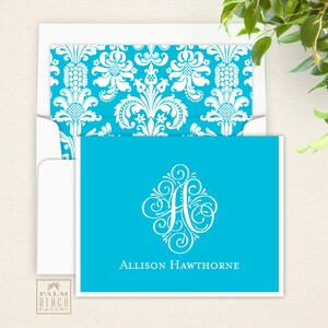 May include: A turquoise blue stationery card with a white monogram of the letter "A" in a decorative font. The text "Allison Hawthorne" is printed below the monogram.