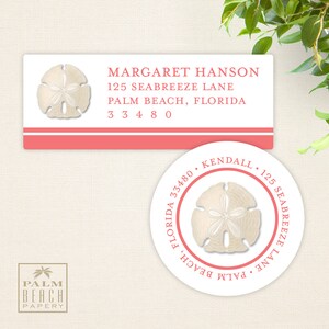 May include: Two white return address labels with a pink border. The top label has a seashell design and the text "MARGARET HANSON 125 SEABREEZE LANE PALM BEACH, FLORIDA 33480". The bottom label is round and has a seashell design with the text "KENDALL 125 SEABREEZE LANE PALM BEACH, FLORIDA 33480".