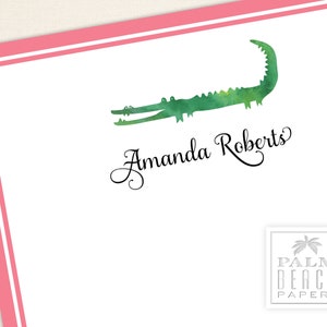 K&ouml;nnte beinhalten: Wei&szlig;es Briefpapier mit rosa Rand und einer Aquarell-Illustration eines Alligators. Der Name "Amanda Roberts" ist in eleganter Schrift geschrieben. Ein Logo von "Palm Beach Papery" befindet sich in der unteren rechten Ecke.