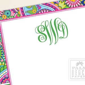 May include: A white card with a pink and green paisley border. The card has a green monogram "SJD" in the center and the text "PALM BEACH PAPERY" in the bottom right corner.