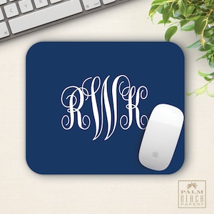 May include: A navy blue mouse pad with a white monogram of the letters RWK. A white computer mouse is on the mouse pad.