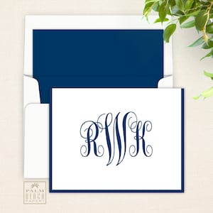May include: A white card with a navy blue border and a navy blue monogram of the letters "R W K" in a script font.