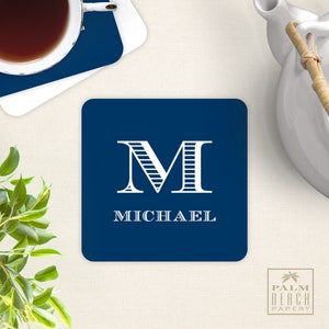 May include: A navy blue square coaster with a white monogram "M" and the name "MICHAEL" printed in white.