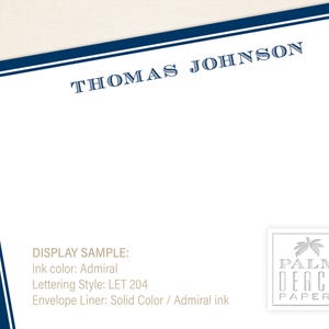 K&ouml;nnte beinhalten: Eine wei&szlig;e Briefpapierkarte mit einem blauen Rand und dem Text "THOMAS JOHNSON" oben. Die Karte enth&auml;lt auch eine Beispielanzeige der Tintenfarbe, des Schriftstils und des Umschlagfutters. Die rechte untere Ecke zeigt ein Logo f&uuml;r "PALM BEACH PAPERY" mit einer Palmengrafik.