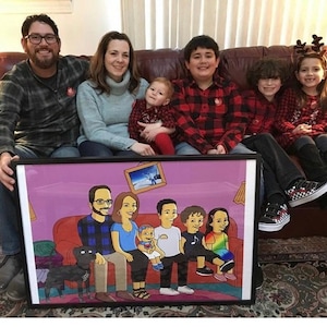 May include: A framed cartoon portrait of a family of seven, including a dog, sitting on a sofa. The cartoon is drawn in a Simpsons-style aesthetic. The portrait is in a black frame and is being held by a family of six in a living room.