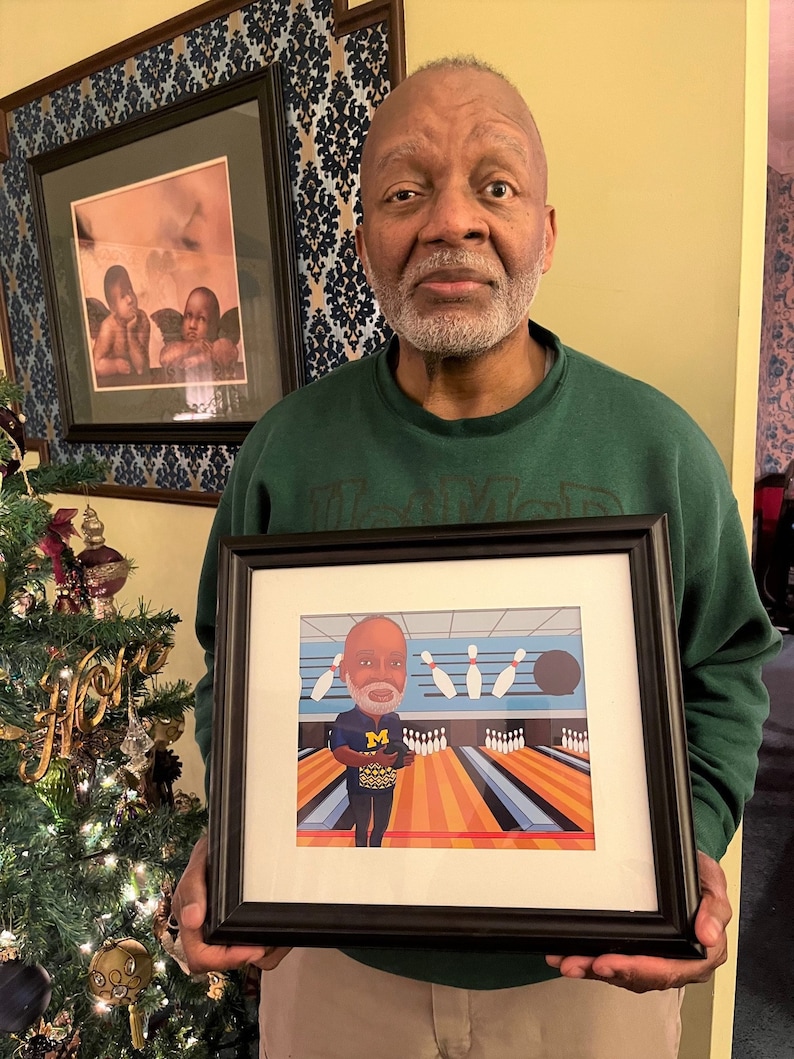 May include: A framed illustration of a person bowling. The person is wearing a green shirt with a blue "M" on it. The bowling alley is blue and orange with a black bowling ball. The illustration is framed in black.