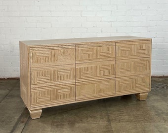 May include: A light wood dresser with three drawers and a geometric pattern on the front. The dresser has a simple design and is made of natural wood.