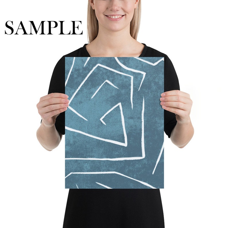 Puede incluir: Una impresi&oacute;n art&iacute;stica rectangular con un fondo verde azulado y l&iacute;neas geom&eacute;tricas blancas. La palabra "SAMPLE" est&aacute; impresa en negro en la parte superior. La impresi&oacute;n es sostenida por una persona.
