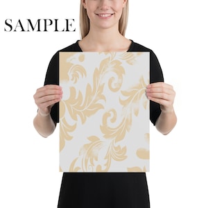 K&ouml;nnte beinhalten: Ein wei&szlig;er Hintergrund mit einem beigefarbenen Blumenmuster. Das Muster ist ein sich wiederholendes Design aus stilisierten Bl&auml;ttern und Wirbeln.