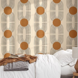 May include: A beige wallpaper with a repeating pattern of brown circles and black arches. The wallpaper is shown in a bedroom setting with a white bed and a brown blanket.
