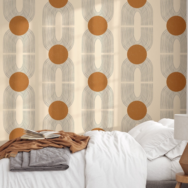 May include: A beige wallpaper with a repeating pattern of brown circles and black arches. The wallpaper is shown in a bedroom setting with a white bed and a brown blanket.