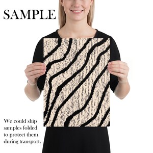 May include: A rectangular print featuring a textured beige background with bold, black, wavy lines. The word "SAMPLE" is printed in large, black capital letters at the top. The print is held by a person.
