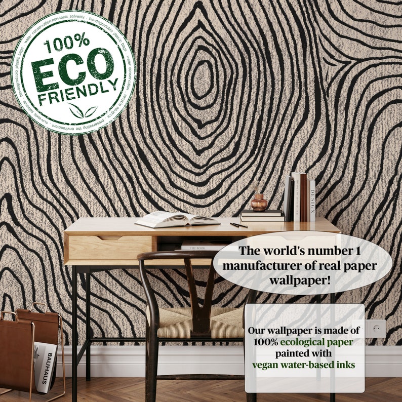 May include: A room with a desk, chair, and wallpaper featuring a black and beige tree ring design. The wallpaper is labeled as 100% ecological paper with vegan water-based inks. The text says "The world's number 1 manufacturer of real paper wallpaper!"