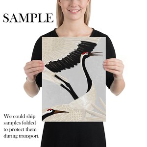 May include: A print depicting two Japanese cranes in flight, with black, white, and red plumage, set against a pale grey backdrop. The word "SAMPLE" is printed at the top.