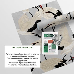 May include: Wallpaper with a repeating pattern of white and black cranes with red details on a grey backdrop. A rolled section of the wallpaper is visible, alongside instructions and a card.