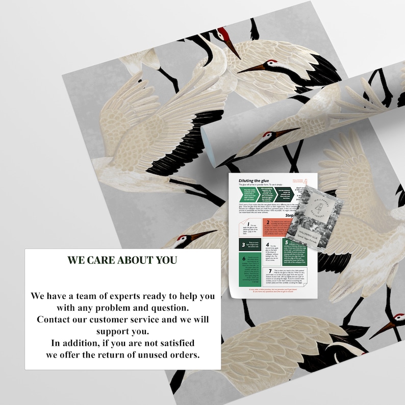 May include: Wallpaper with a repeating pattern of white and black cranes with red details on a grey backdrop. A rolled section of the wallpaper is visible, alongside instructions and a card.