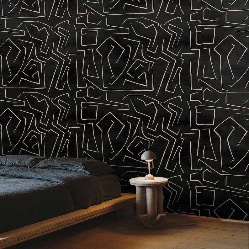 May include: A black and white geometric patterned wallpaper with a black bed and a small black side table with a lamp.